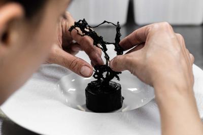 Assortiment de viennoiseries et fruits frais disposés sur un comptoir en métal dans un espace lumineux.