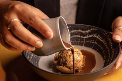 Assortiment de viennoiseries et fruits frais disposés sur un comptoir en métal dans un espace lumineux.