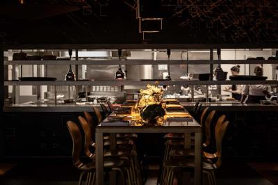 Assortiment de viennoiseries et fruits frais disposés sur un comptoir en métal dans un espace lumineux.