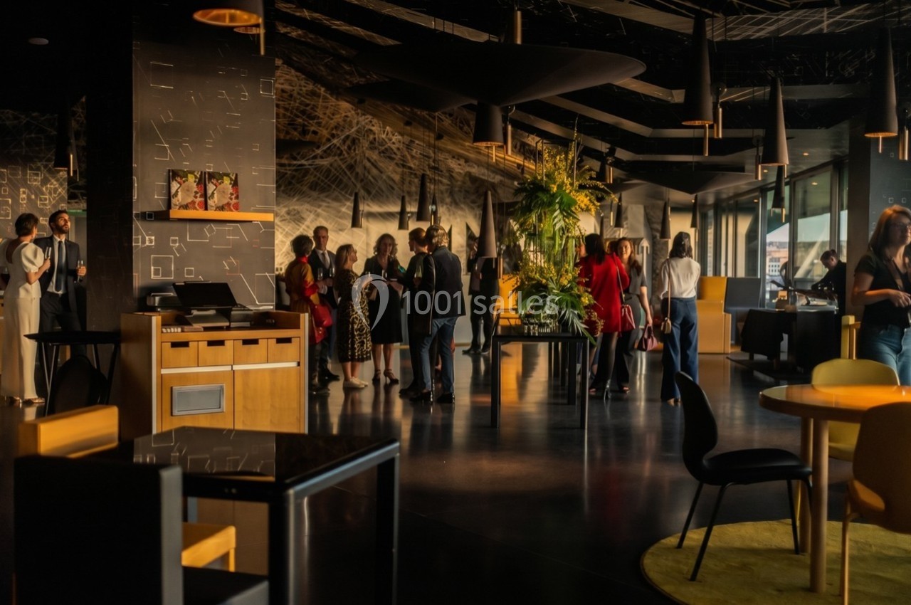 Des personnes discutent dans un espace intérieur moderne avec une décoration élégante et des plantes.