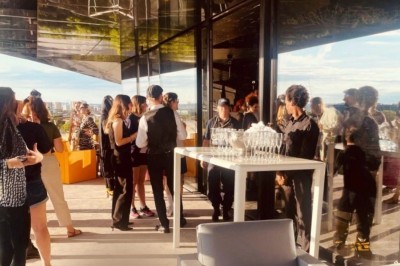 Miniature Location salle Paris 19 (Paris) - L'Envol de la Philharmonie #24 Groupe de personnes rassemblées sur une terrasse panoramique ensoleillée avec vue dégagée, mobilier moderne au premier plan.
