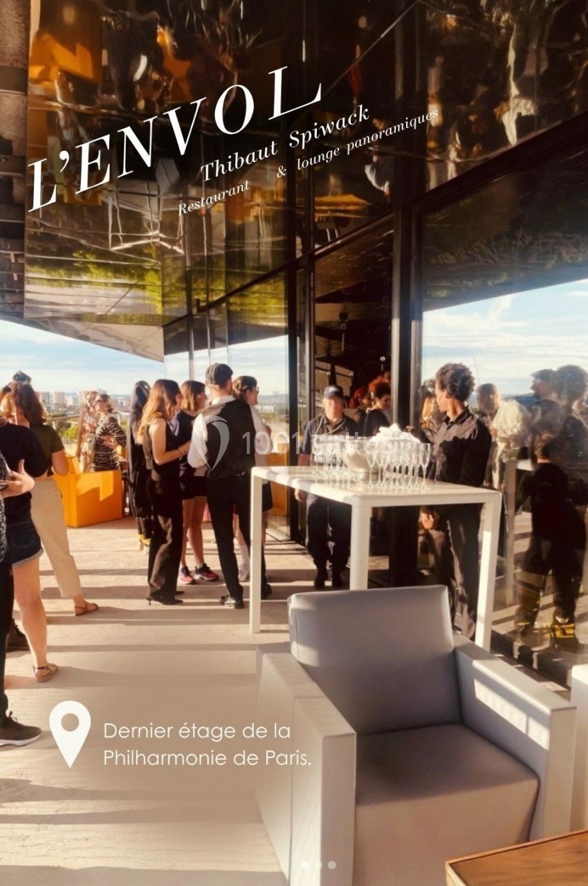 Groupe de personnes rassemblées sur une terrasse panoramique ensoleillée avec vue dégagée, mobilier moderne au premier plan.