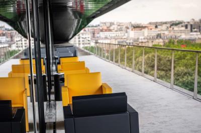 Un barman verse un liquide sombre d'une petite bouteille dans un verre à cocktail rempli d'une boisson mousseuse.