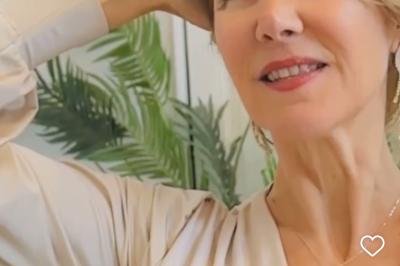 Salle de bain moderne avec lavabo double, miroir, toilettes grises et étagères décorées de plantes et flacons.