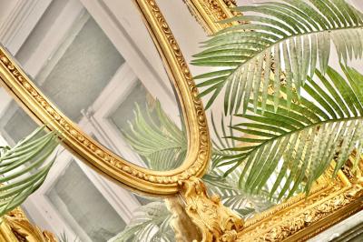 Salle de bain moderne avec lavabo double, miroir, toilettes grises et étagères décorées de plantes et flacons.