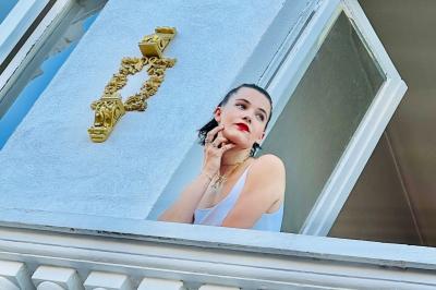 Salle de bain moderne avec lavabo double, miroir, toilettes grises et étagères décorées de plantes et flacons.