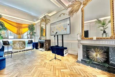 Salle de bain moderne avec lavabo double, miroir, toilettes grises et étagères décorées de plantes et flacons.