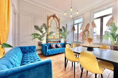 Salle de bain moderne avec lavabo double, miroir, toilettes grises et étagères décorées de plantes et flacons.