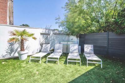 Salle de bain moderne avec lavabo double, miroir, toilettes grises et étagères décorées de plantes et flacons.
