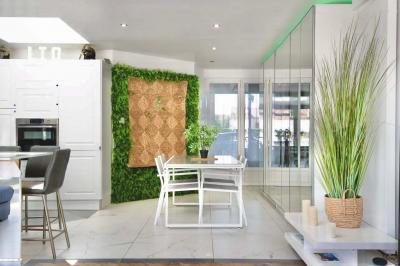 Salle de bain moderne avec lavabo double, miroir, toilettes grises et étagères décorées de plantes et flacons.