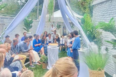 Salle de bain moderne avec lavabo double, miroir, toilettes grises et étagères décorées de plantes et flacons.