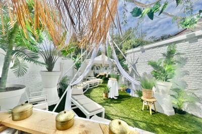 Salle de bain moderne avec lavabo double, miroir, toilettes grises et étagères décorées de plantes et flacons.