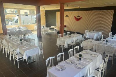 Allée extérieure éclairée par des lampadaires, bordée de bancs, d'arbustes et d'un parterre de fleurs.