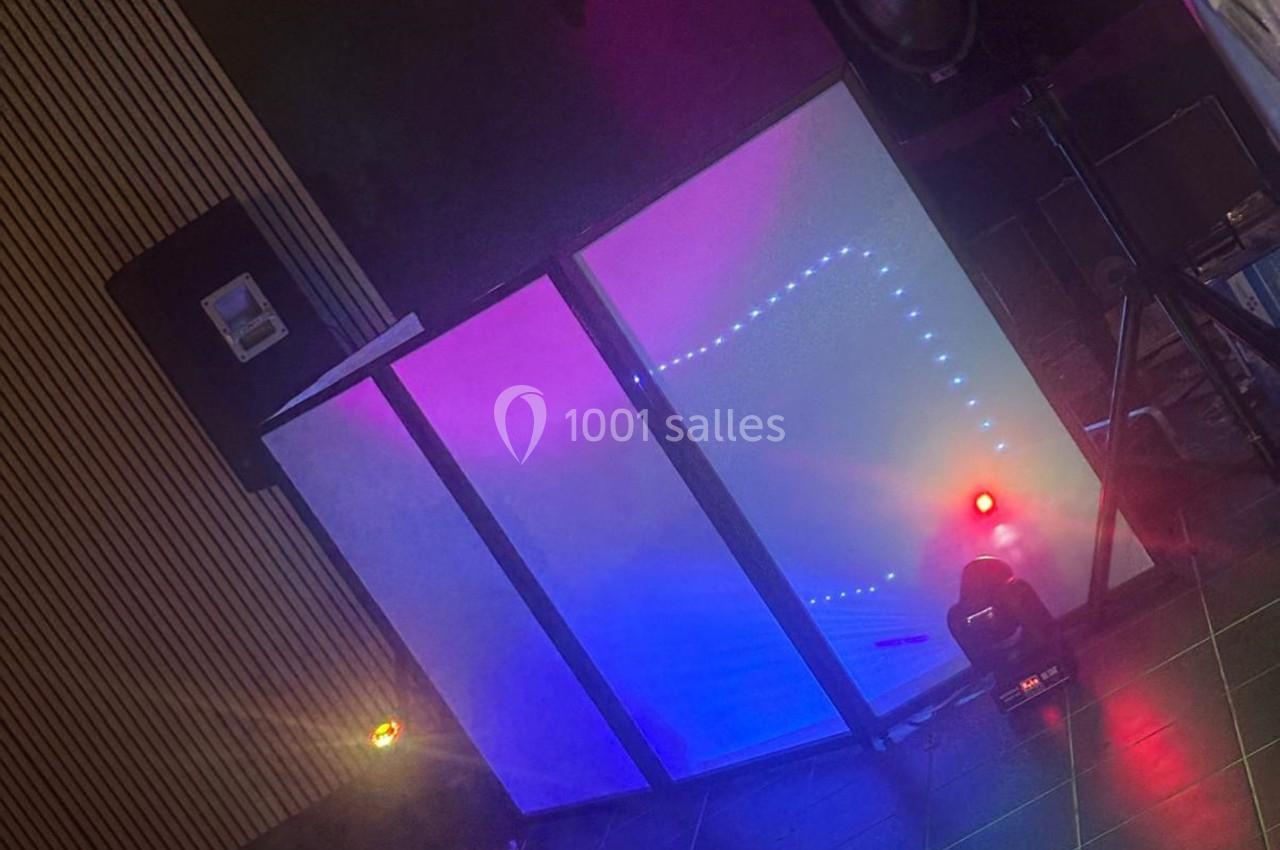 Panneau lumineux avec éclairages colorés et projecteurs dans un espace intérieur sombre.