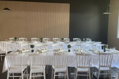 Allée extérieure éclairée par des lampadaires, bordée de bancs, d'arbustes et d'un parterre de fleurs.