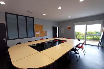 Vue d'un terrain de golf avec des joueurs sur le green, entouré d'arbres et d'un bâtiment en arrière-plan.