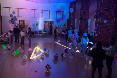 Salle de réception avec murs en pierre, poutres apparentes, tables dressées et éclairage tamisé.