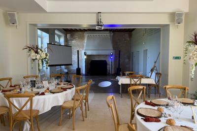 Mariés entrant dans une salle de réception décorée, entourés de jets d'étincelles et de tables dressées.