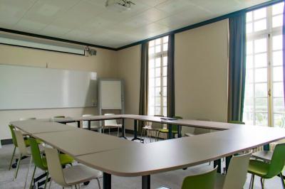 Statue de sphinx en pierre posée sur un socle, entourée de verdure dans un jardin.