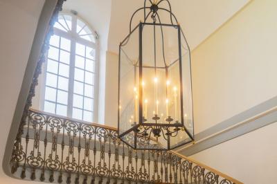 Statue de sphinx en pierre posée sur un socle, entourée de verdure dans un jardin.