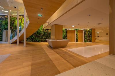 Vue d'une terrasse végétalisée surplombant Paris avec la Tour Eiffel visible à l'horizon sous un ciel bleu.