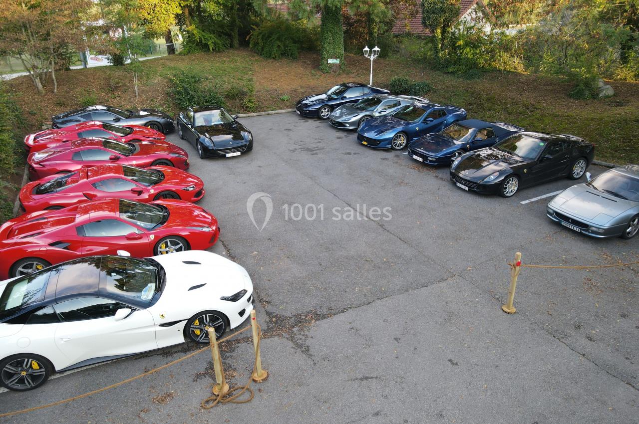 Rassemblement de voitures de sport garées en extérieur, alignées en deux rangées sur un parking.