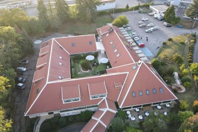 Garage avec sol en béton, mur en parpaings, éclairage au néon, et sortie donnant sur une allée extérieure.