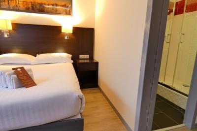 Garage avec sol en béton, mur en parpaings, éclairage au néon, et sortie donnant sur une allée extérieure.