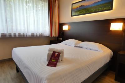 Garage avec sol en béton, mur en parpaings, éclairage au néon, et sortie donnant sur une allée extérieure.