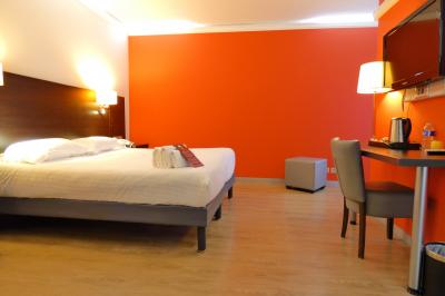 Garage avec sol en béton, mur en parpaings, éclairage au néon, et sortie donnant sur une allée extérieure.