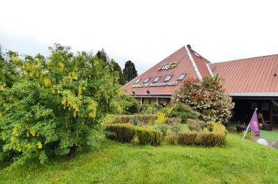 Garage avec sol en béton, mur en parpaings, éclairage au néon, et sortie donnant sur une allée extérieure.