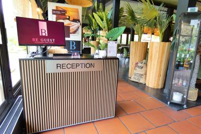 Garage avec sol en béton, mur en parpaings, éclairage au néon, et sortie donnant sur une allée extérieure.