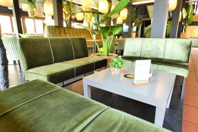 Garage avec sol en béton, mur en parpaings, éclairage au néon, et sortie donnant sur une allée extérieure.