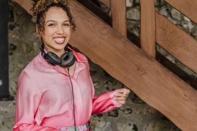 Personne ajustant les commandes d'une table de mixage en plein air, avec de l'herbe en arrière-plan.