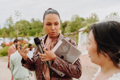 Personne ajustant les commandes d'une table de mixage en plein air, avec de l'herbe en arrière-plan.
