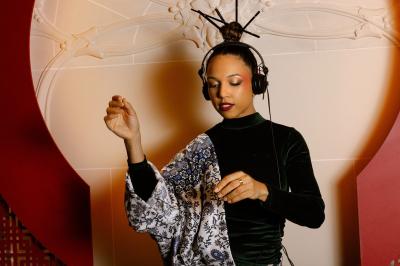 Une DJ mixant de la musique sur une table de mixage dans une ambiance lumineuse violette.