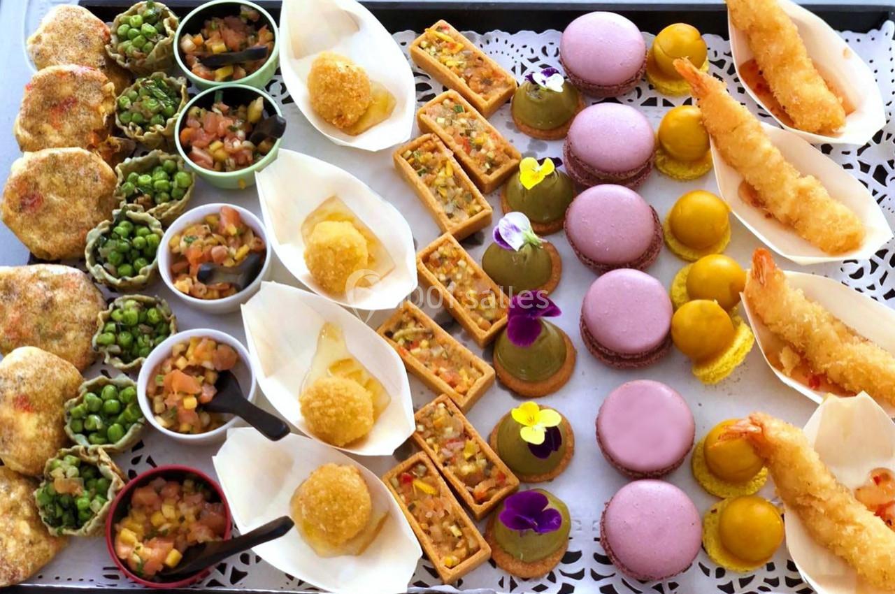 Plateau de bouchées variées comprenant macarons, beignets, verrines, légumes, crevettes et tartelettes colorées.
