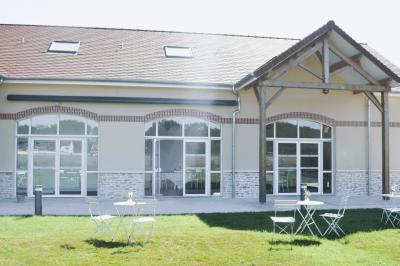 Table dressée en extérieur avec des plats, ustensiles de cuisine et présentoirs en bois devant une haie verte.