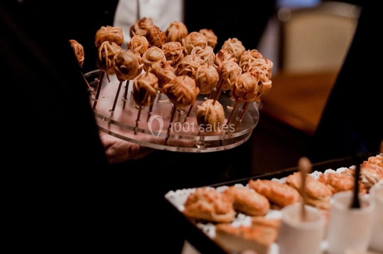 Plateaux de bouchées apéritives variées, dont des brochettes et des verrines, servis lors d'un événement.