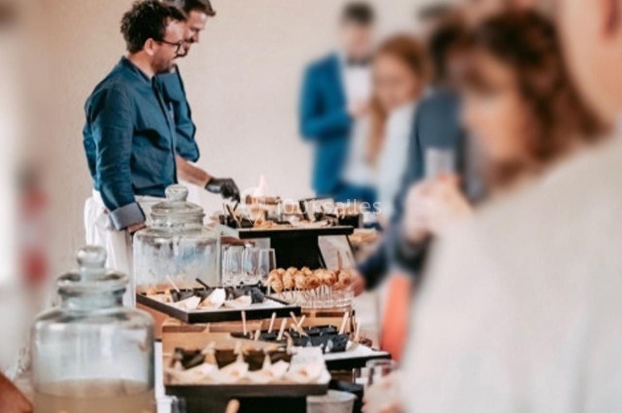 Des personnes se servent à un buffet composé de desserts et de boissons dans un cadre convivial.