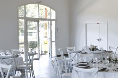 Table dressée en extérieur avec des plats, ustensiles de cuisine et présentoirs en bois devant une haie verte.