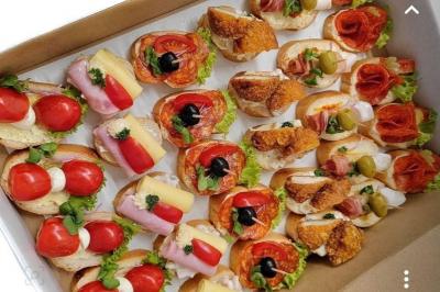 Buffet avec plusieurs plats chauds en marmites en inox, accompagné de sauces et d'assiettes en arrière-plan.