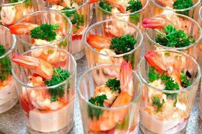 Buffet avec plusieurs plats chauds en marmites en inox, accompagné de sauces et d'assiettes en arrière-plan.