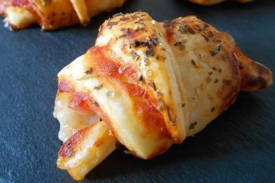 Buffet avec plusieurs plats chauds en marmites en inox, accompagné de sauces et d'assiettes en arrière-plan.