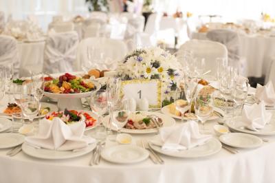Buffet avec plusieurs plats chauds et froids présentés dans des récipients en inox sur une table noire.