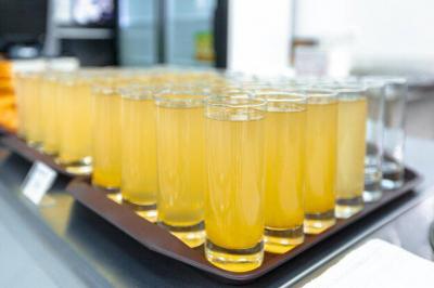Buffet avec plusieurs plats chauds et froids présentés dans des récipients en inox sur une table noire.