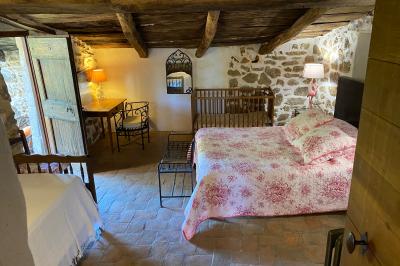 Une rangée de vélos garés sous des arbres dans un espace vert, avec une personne en arrière-plan.