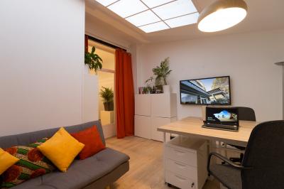 Cuisine étroite avec électroménagers, étagères murales, carrelage au sol et éclairage suspendu.