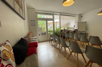 Cuisine étroite avec électroménagers, étagères murales, carrelage au sol et éclairage suspendu.