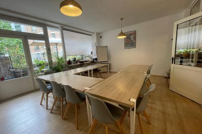 Cuisine étroite avec électroménagers, étagères murales, carrelage au sol et éclairage suspendu.